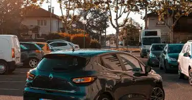 black sedan parked beside white car during daytime