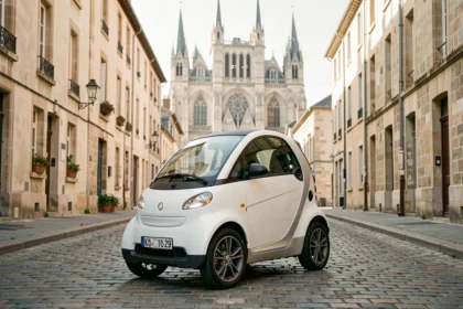 Voiture sans permis blanche garée dans le centre historique de Bourges avec la cathédrale Saint-Étienne en arrière-plan